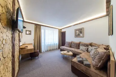 a living room with a couch and a table at Българче Хотел - Ресторант in Smolyan