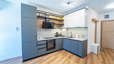 a kitchen with blue cabinets and a wooden floor at Niko's Cozy Apartment in Plovdiv