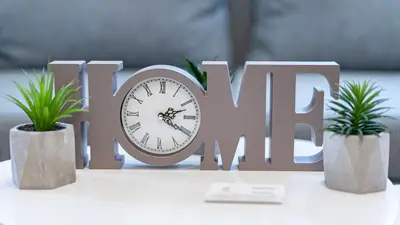 a sign with a clock and two potted plants at Niko's Cozy Apartment in Plovdiv