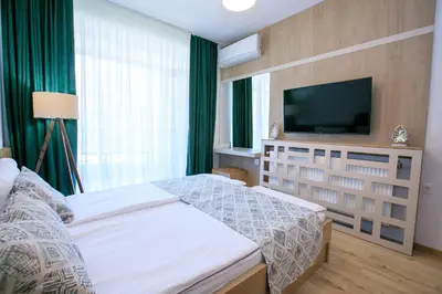 a bedroom with a bed and a flat screen tv at Лукс Апартамент Радост 2 in Sandanski
