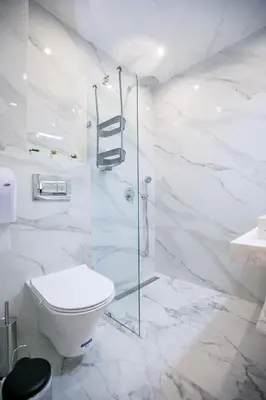 a white bathroom with a toilet and a shower at Лукс Апартамент Радост 2 in Sandanski
