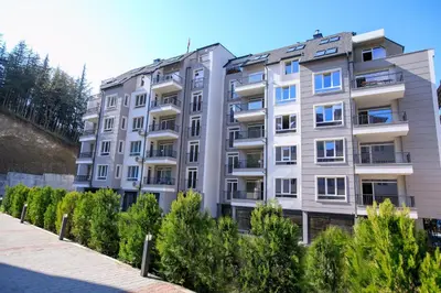 an apartment building with trees in front of it at Лукс Апартамент Радост 2 in Sandanski