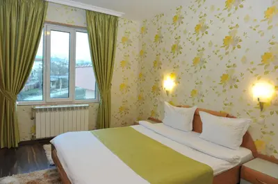 a bedroom with a large bed and a window at Eros Motel in Sandanski