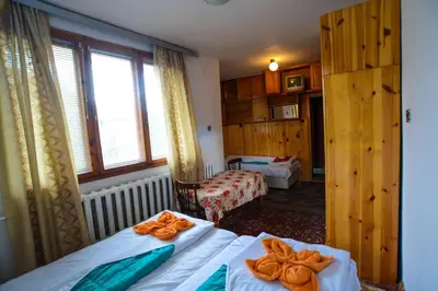a hotel room with two beds with orange bows on them at Topuzovi Guest House in Dobrinishte