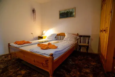 a bedroom with a bed with orange robes on it at Topuzovi Guest House in Dobrinishte