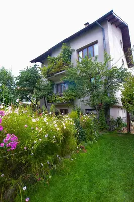 a house with flowers in front of it at Topuzovi Guest House in Dobrinishte