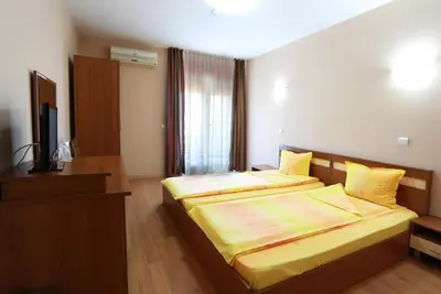 a hotel room with two beds and a television at Acropolis Hotel in Pazardzhik
