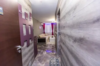 a hallway with a door and a living room at Апартаменти Елеганс in Sandanski