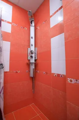 a shower in a bathroom with orange and white tiles at Feel at Home in Sandanski