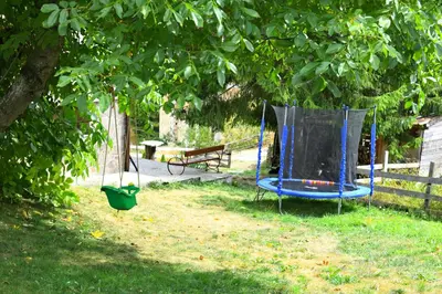 a blue trampoline in a yard under a tree at КЪЩА ЗА ГОСТИ “НИЯ” in Smolyan
