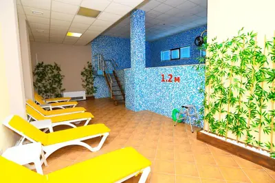 a waiting room with yellow chairs and a wall with plants at Sweet Home апартамент 530 Смолянски езера in Smolyan