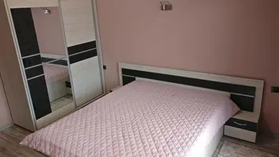 a bedroom with a bed and a large mirror at Къща за гости Роял in Sandanski
