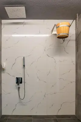 a bathroom with a white marble wall with a shower at Студио с вана и гледка в 