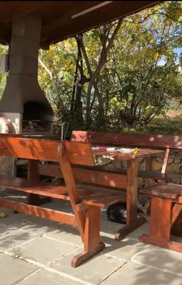 a wooden bench sitting next to a stove at Sunshine villa Dzhigurovo in Sandanski