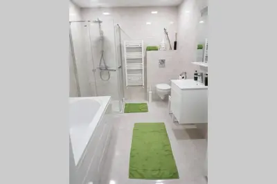 a bathroom with a shower and a green rug at GUESTHOUSE MARIA / КЪЩА ЗА ГОСТИ МАРИЯ / GÄSTEHAUS MARIA in Karlovo