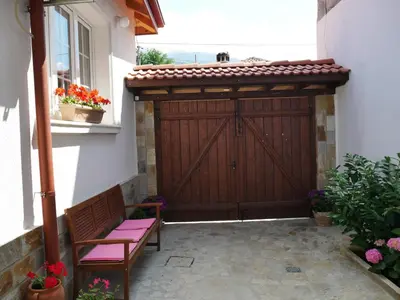 a wooden garage door with a bench in front of it at GUESTHOUSE MARIA / КЪЩА ЗА ГОСТИ МАРИЯ / GÄSTEHAUS MARIA in Karlovo