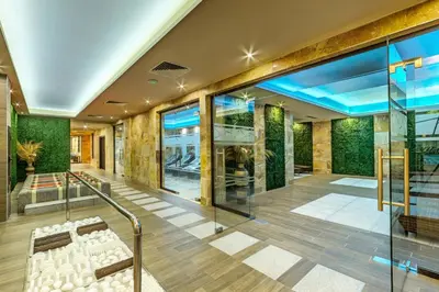 a lobby of a building with a staircase and chairs at Villa Dea & Villa Ina - Villas & SPA Park in Velingrad by Flat Mаnager in Velingrad