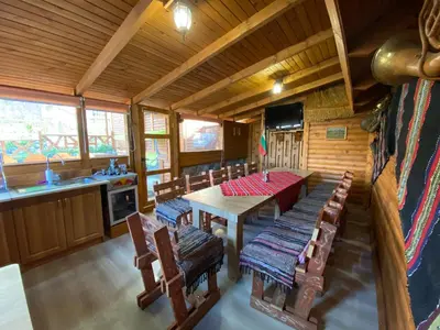 a dining room with a table and chairs in a cabin at Тихият кът in Sapareva Banya
