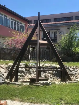 a wooden structure in front of a house at Тихият кът in Sapareva Banya