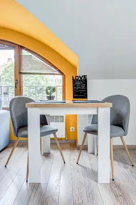 a table with three chairs and a sign on it at Park Loft next to Eagle's Bridge in Sofia