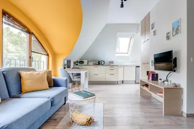 a living room with a blue couch and a kitchen at Park Loft next to Eagle's Bridge in Sofia