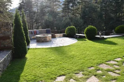 a garden with a bench and trees and grass at Moiata Kashta Villa in Popovi Livadi
