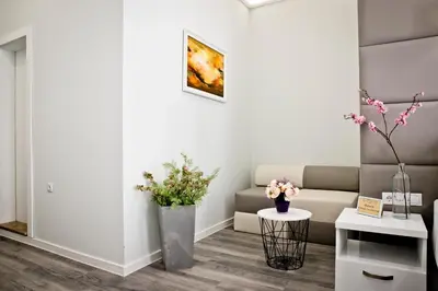 a living room with a couch and flowers on the floor at Plovdiv City Center Hotel in Plovdiv