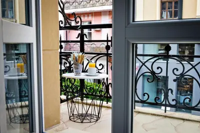 a balcony with a table with a cup on it at Plovdiv City Center Hotel in Plovdiv