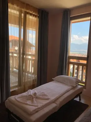 a bedroom with a bed and a large window at Mirabell Apartment Bansko - Mountain View & Fireplace in Bansko