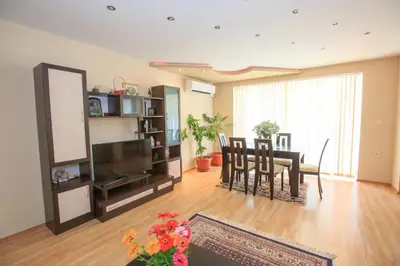 a living room with a table and a dining room at Мария Парк in Sandanski