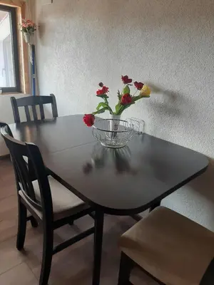 a table with a vase of flowers on top of it at Къща за гости Алекс in Karlovo