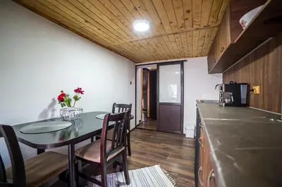 a small kitchen with a table and chairs and a counter at Къща за гости Алекс in Karlovo