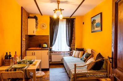 a living room with yellow walls and a couch at Art apartment EVMOLPIAS near Roman stadium in Plovdiv