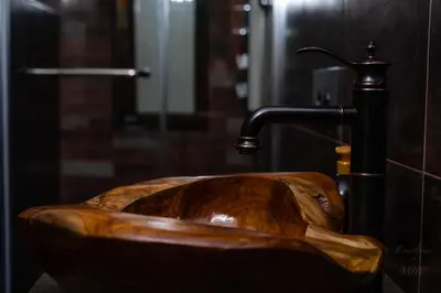 a wooden sink in a bathroom with a faucet at Art apartment EVMOLPIAS near Roman stadium in Plovdiv