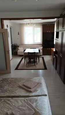 a living room with a table and a kitchen at Къща за гости - Софи, гр. Девин in Devin