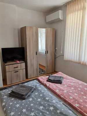 a bedroom with a bed and a tv and a mirror at Къща за гости - Софи, гр. Девин in Devin