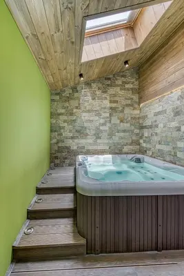 a jacuzzi tub in a room with green walls at Pirin Style Villa & Spa in Bansko