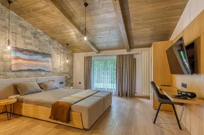 a bedroom with a large bed and a television in it at Pirin Style Villa & Spa in Bansko