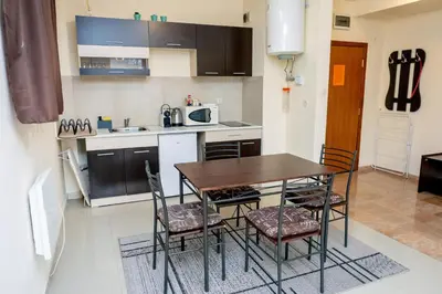 a kitchen with a table and chairs in a room at Villa Kalina Apartments in Bansko