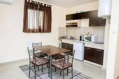 a small kitchen with a wooden table and chairs at Villa Kalina Apartments in Bansko