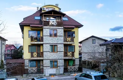 an old house with a turret on a street at Villa Kalina Apartments in Bansko