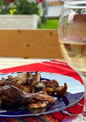 a plate of food on a table with a glass of wine at Къща за гости 