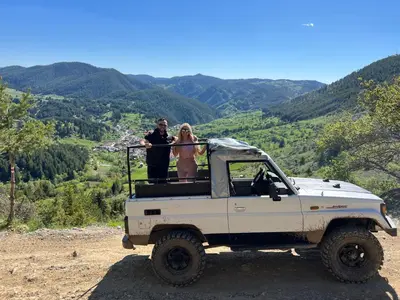 two people standing in the back of a white truck at Къща за гости 