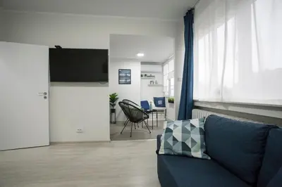 a living room with a couch and a flat screen tv at Landmark Apartment in Sofia