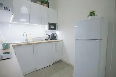 a kitchen with white cabinets and a white refrigerator at Landmark Apartment in Sofia