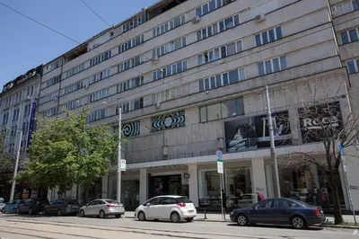 a large building with cars parked in front of it at Landmark Apartment in Sofia