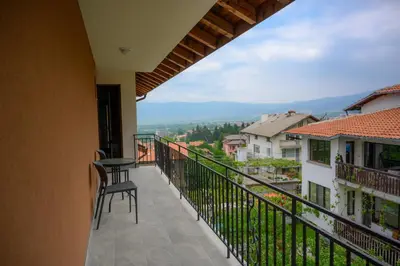 a balcony of a house with a table and chairs at Вила Влахов in Sapareva Banya