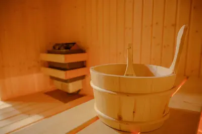 a wooden bucket with a spoon in it next to books at Вила Влахов in Sapareva Banya