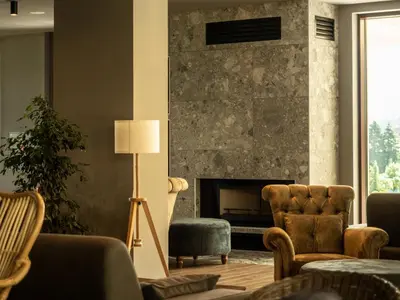 a living room with a stone fireplace and chairs at The Five Elements Hotel and SPA in Sapareva Banya
