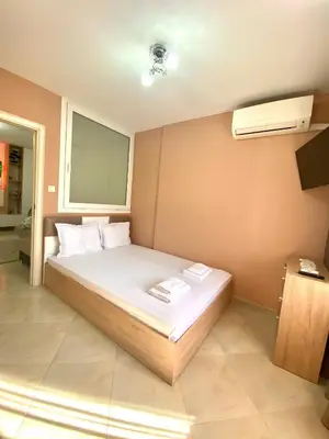 a bedroom with a white bed with a window at Irina Apartment in Sandanski